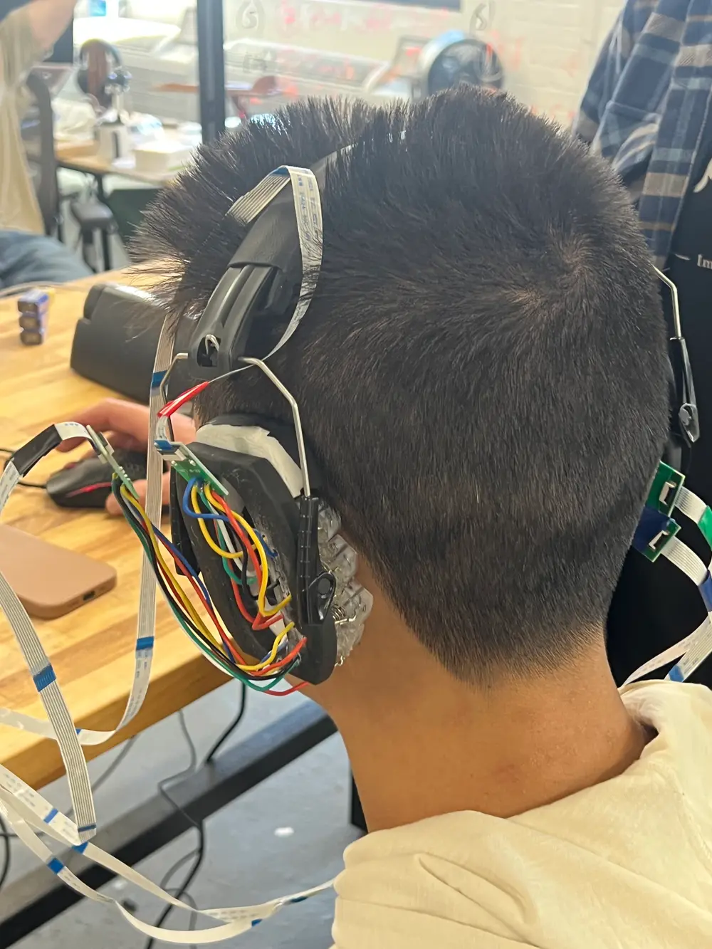 Prototype ear-worn electrode headset with ribbon cables during fitting