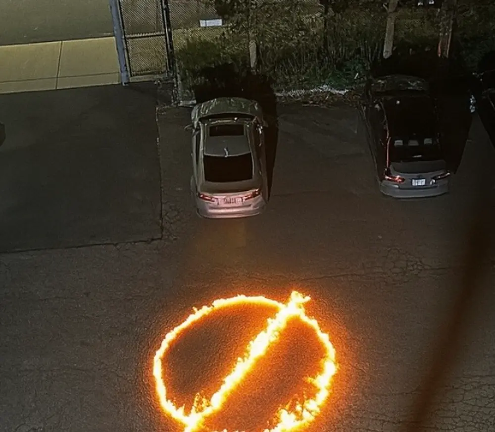 Circle-and-slash symbol burning on a parking lot at night