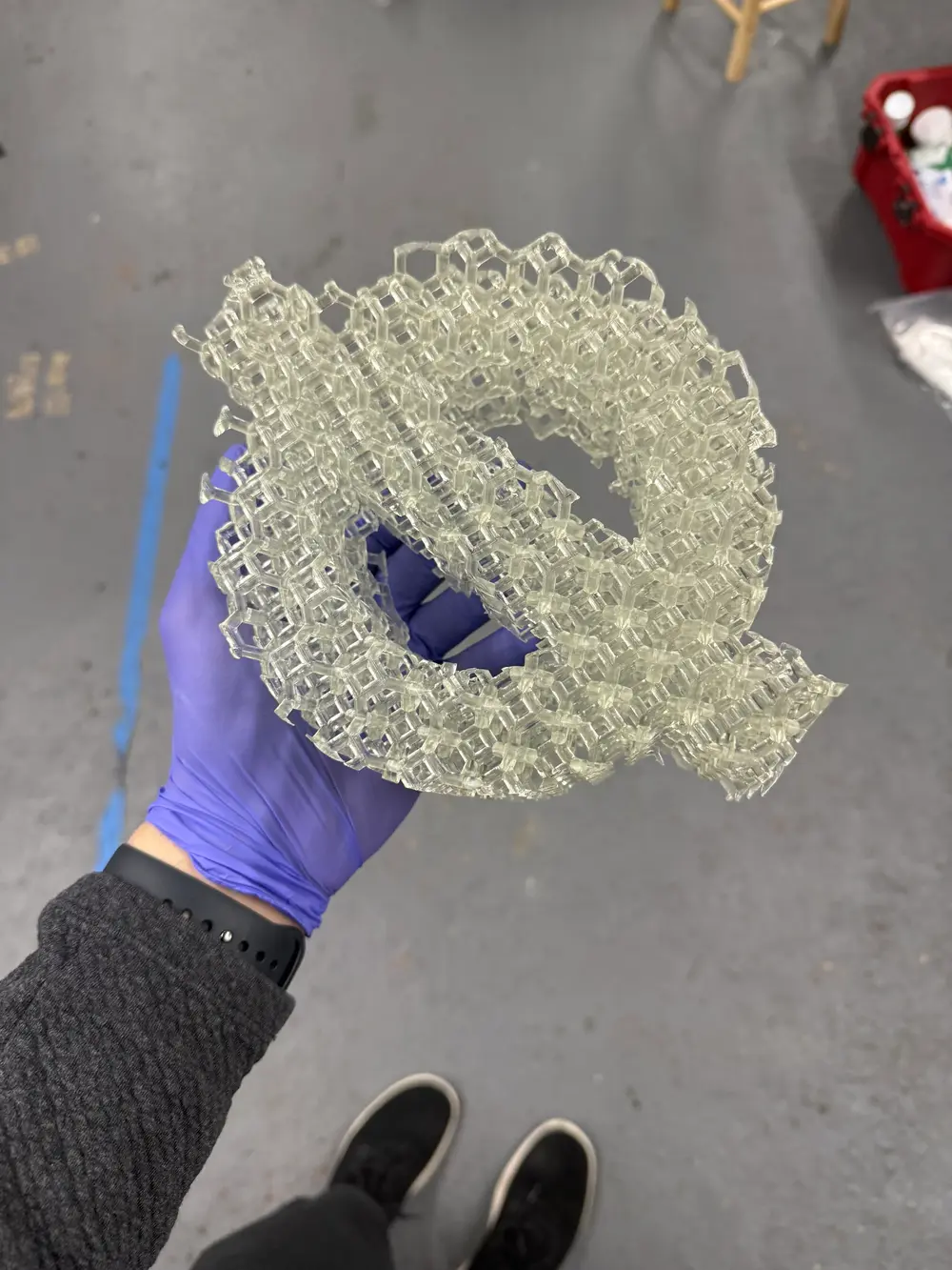 Holding a 3D-printed resin lattice in a gloved hand