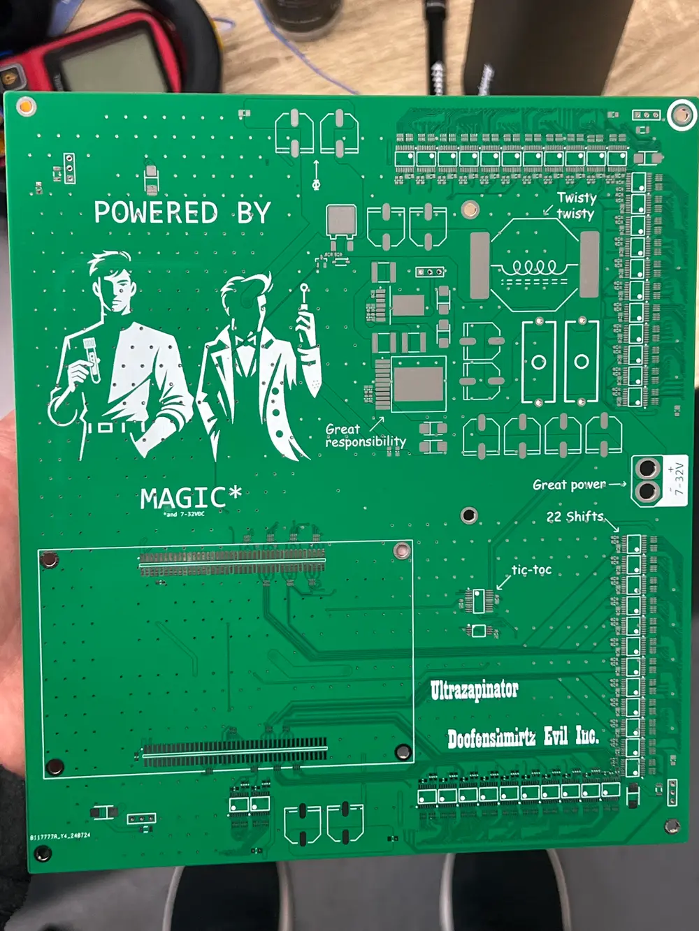 Bare green circuit board with playful Doofenshmirtz-themed silkscreen art